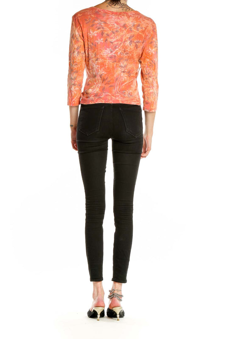 Side view of Boho Chic coral floral asymmetric button-up top on model