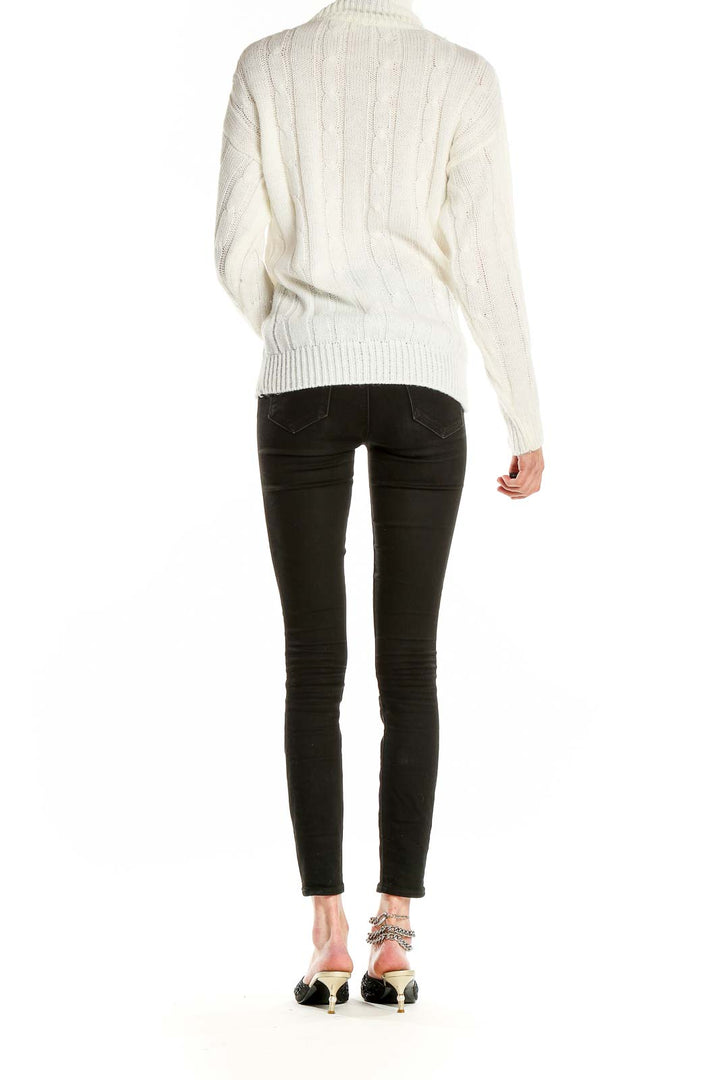 Side view of Nan Dorsey cream cable knit turtleneck sweater on model
