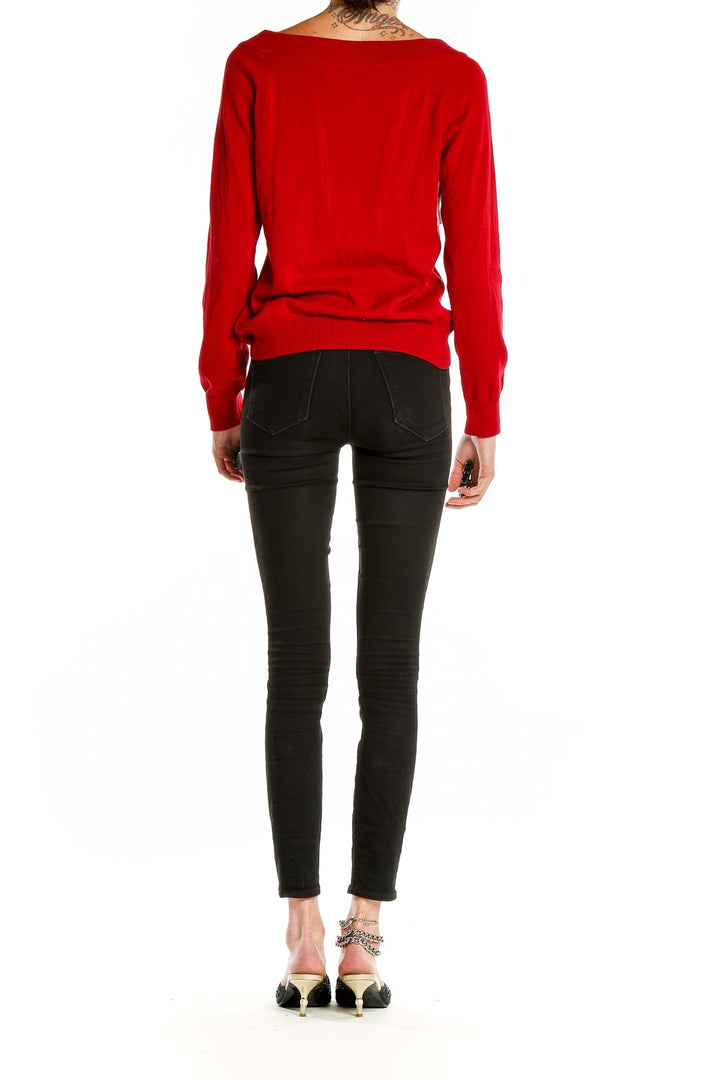 Side view of Lauren Ralph Lauren red knit sweater on model with black pants