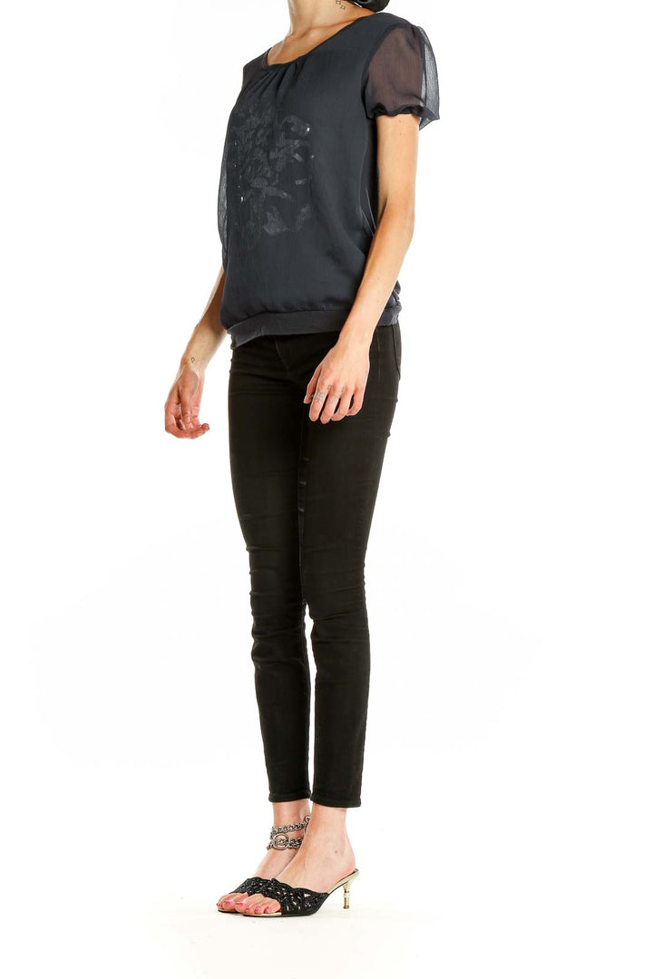 Front view of Cynthia Rowley black top with silver floral print and sheer sleeves