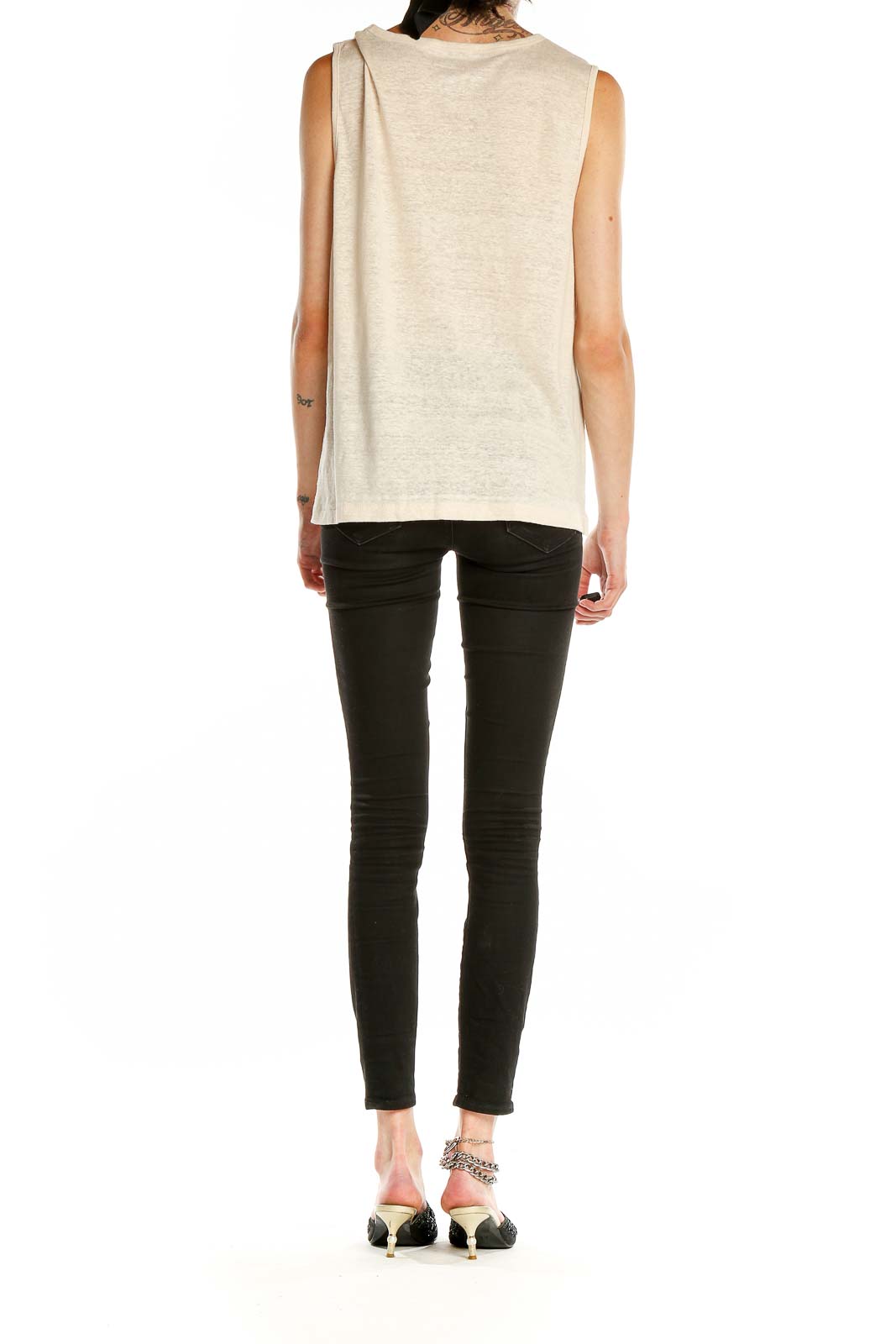 Side view of J.Crew beige sleeveless top on model with black pants
