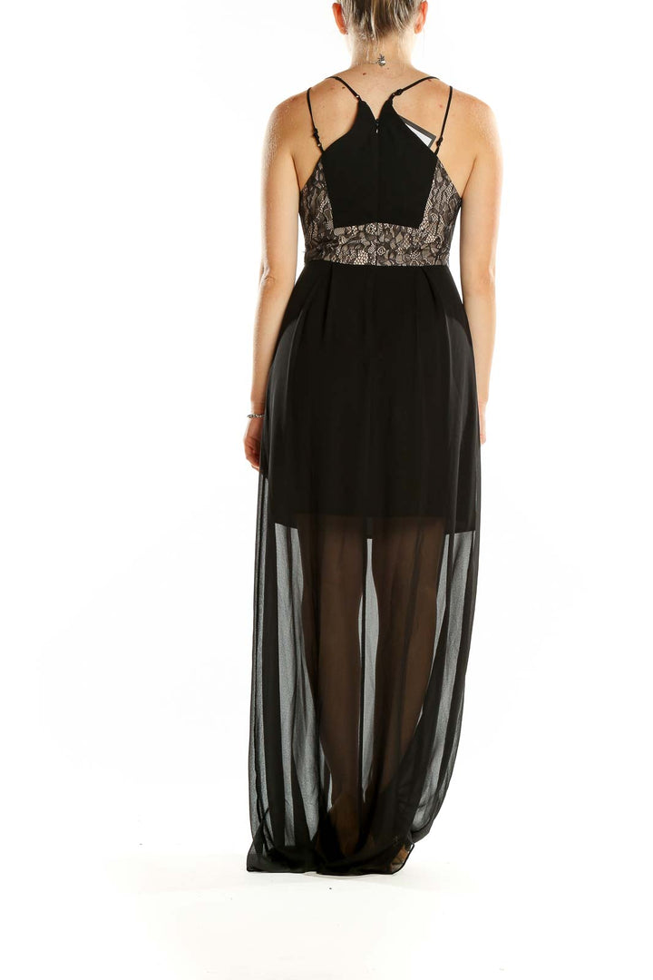 Back view of BCBGeneration black maxi dress showing criss-cross strap detail and sheer full-length skirt
