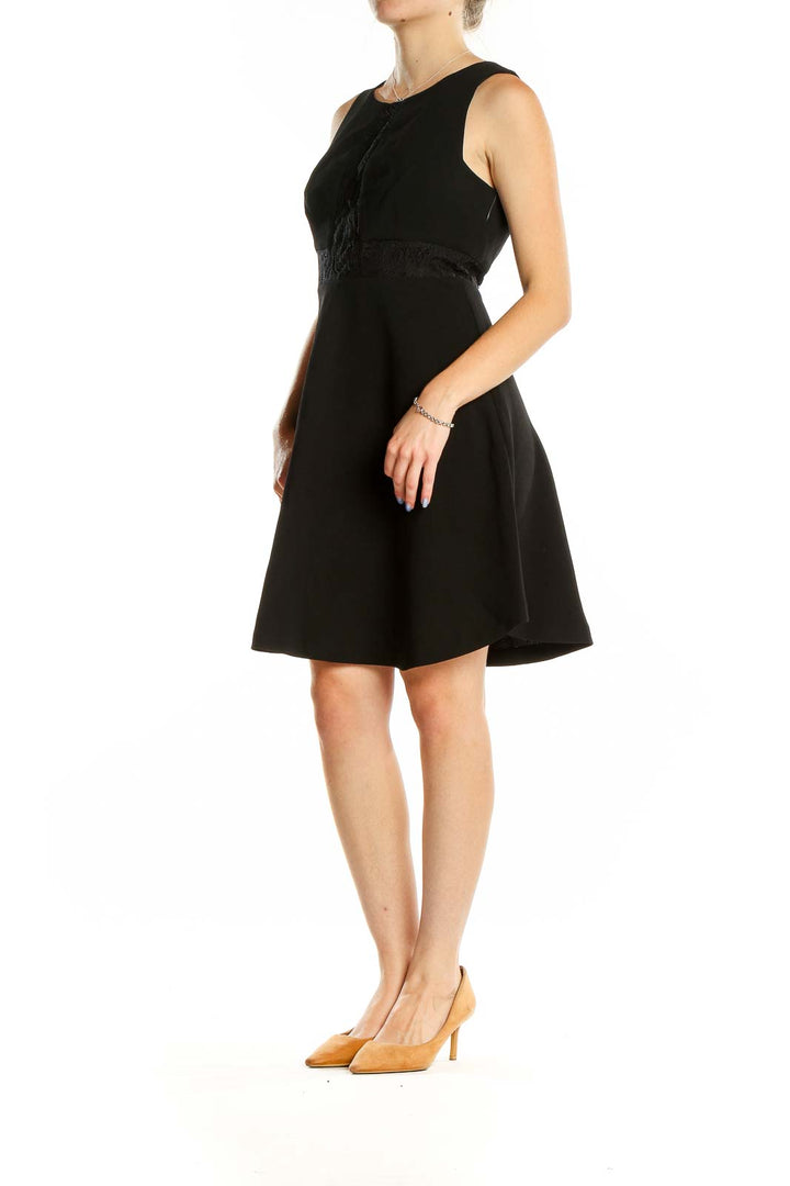Front view of BCBGeneration black sleeveless cocktail dress with lace detail