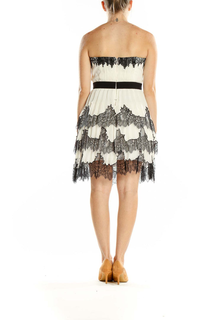 Back view of BCBG MaxAzria white lace strapless cocktail dress showing zipper closure and tiered lace detail