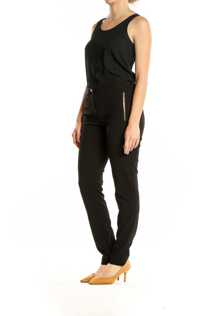 Front view of Calvin Klein black straight-leg pants with gold zipper accents