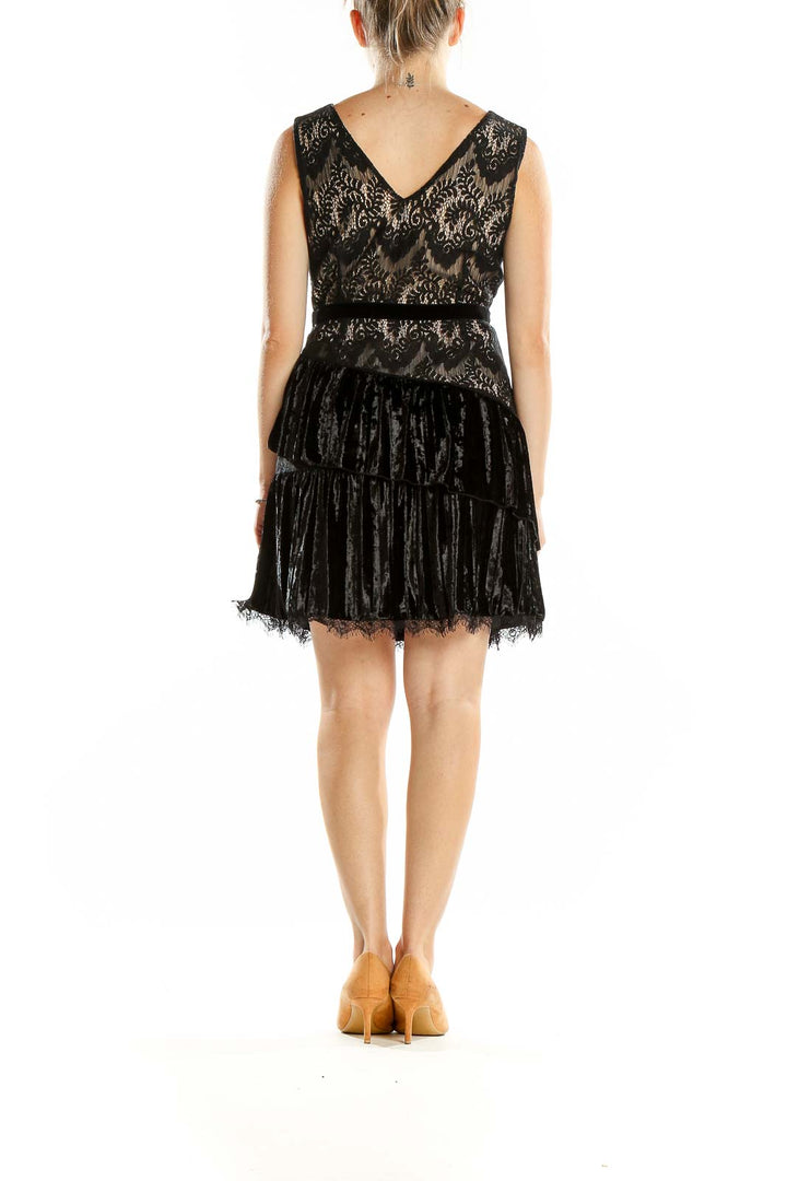 Back view of Foxiedox black lace and velvet mini dress showing V-back and tiered velvet skirt
