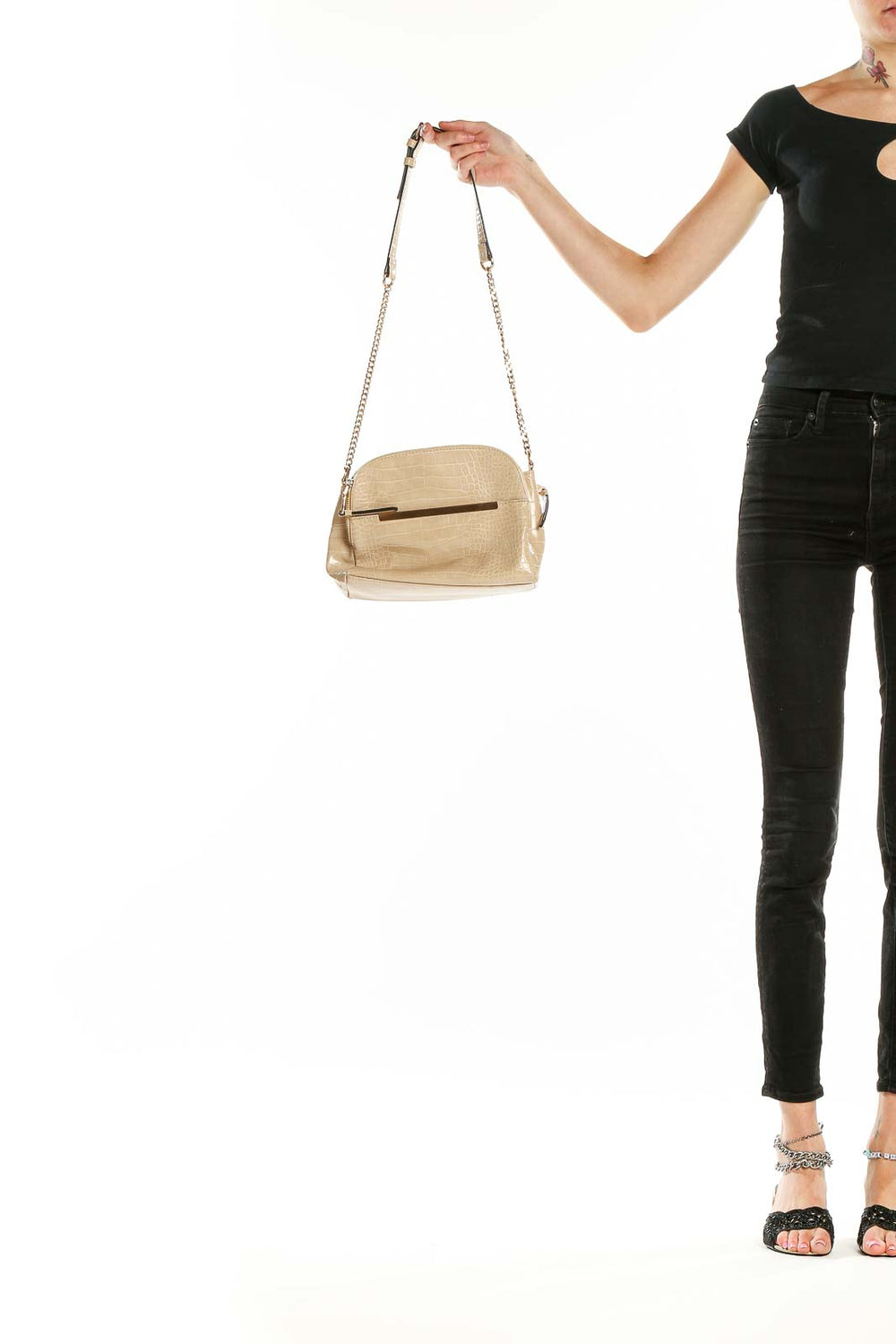 Front view of beige croc-embossed crossbody bag with gold-tone accent