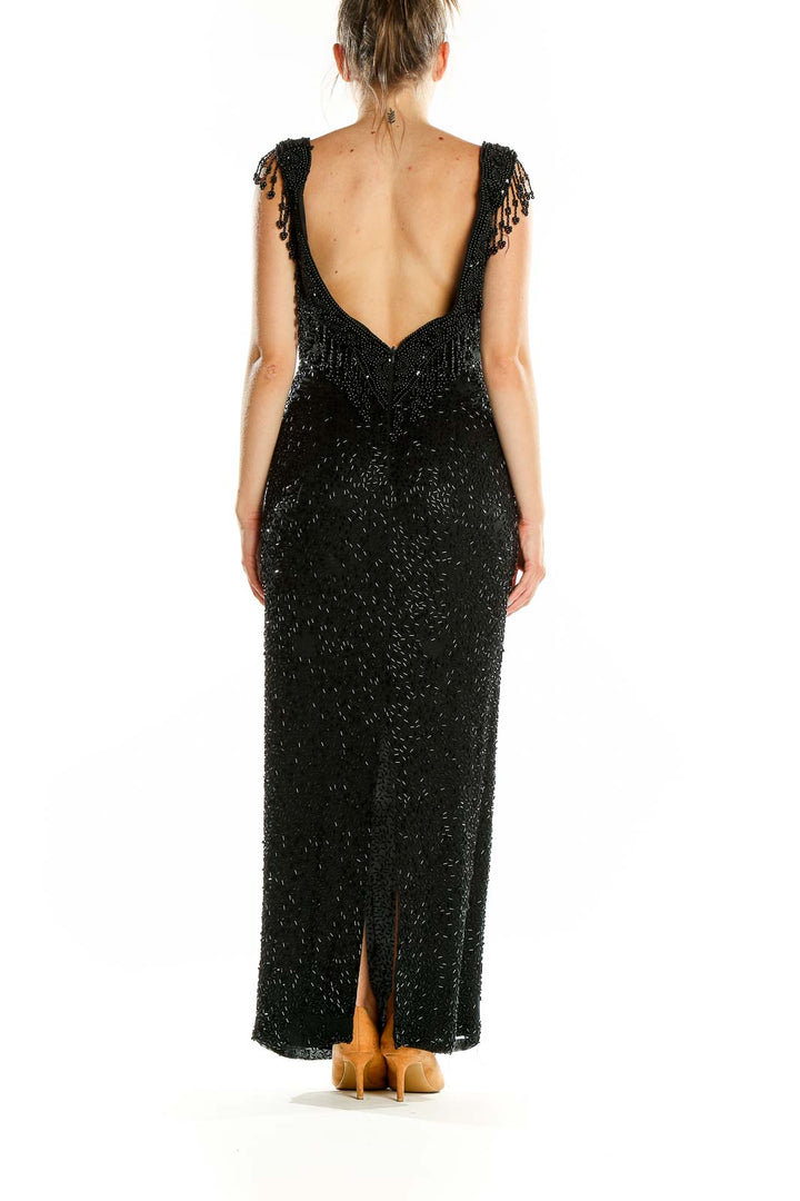 Back view of black beaded maxi dress showing open back design and floor-length silhouette