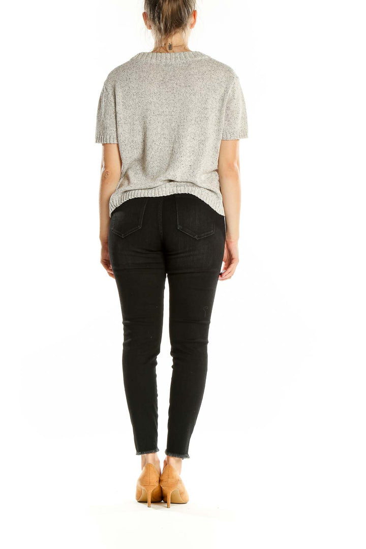 Back view of Madewell gray short-sleeve knit sweater on model with black jeans