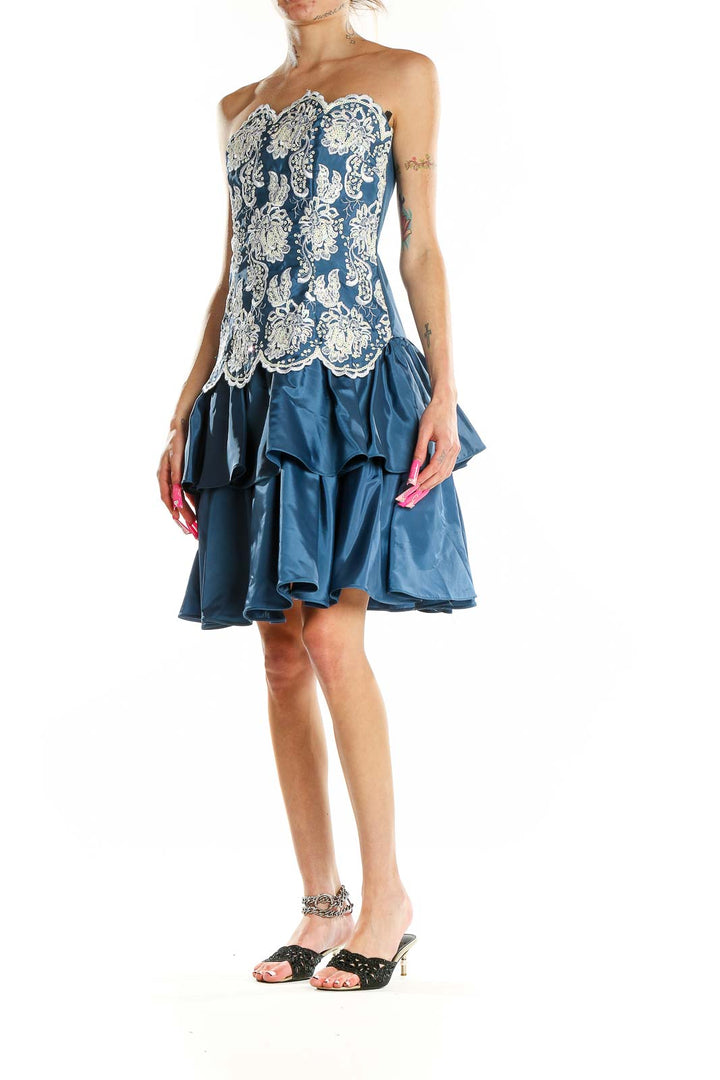 Front view of Scott McClintock blue cocktail dress with white lace overlay and tiered skirt