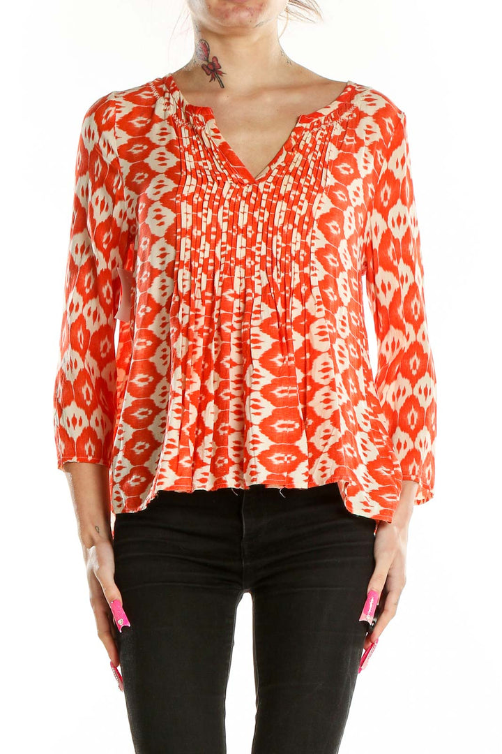 Front view of VANESSAVIRGINIA orange ikat print rayon blouse with V-neck and pintuck pleating