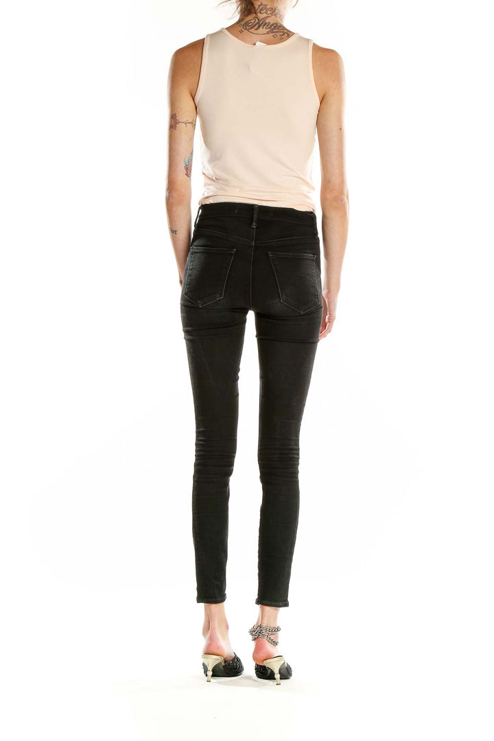 Side view of J.Crew beige tank top paired with black jeans