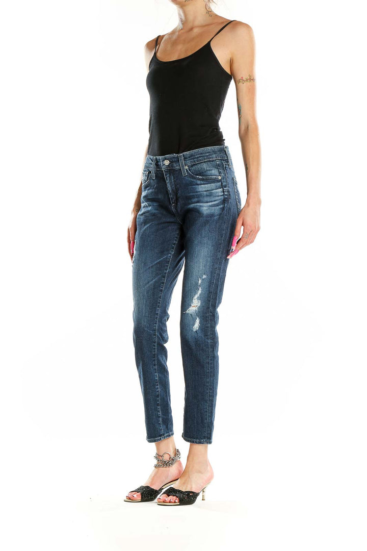 Front view of AG blue distressed slim fit jeans on model