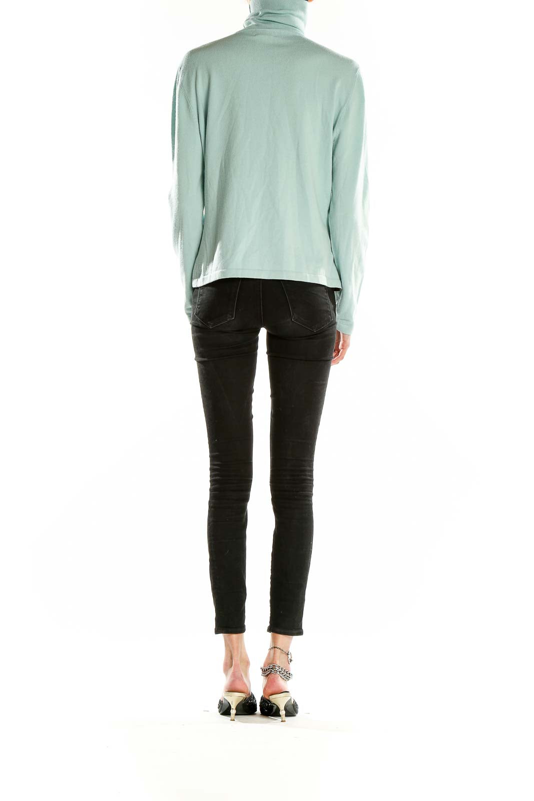 Side view of mint green Faconnable turtleneck sweater on model with black pants