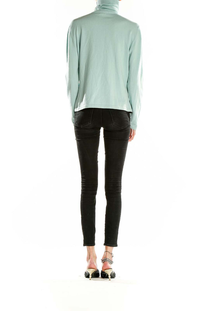 Side view of mint green Faconnable turtleneck sweater on model with black pants