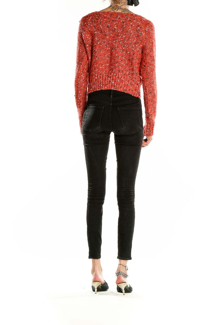 Side view of red speckled cropped sweater by John + Jenn with black jeans
