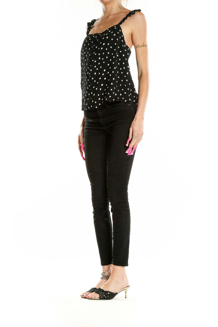 Front view of Madewell black polka dot tank top with ruffle straps