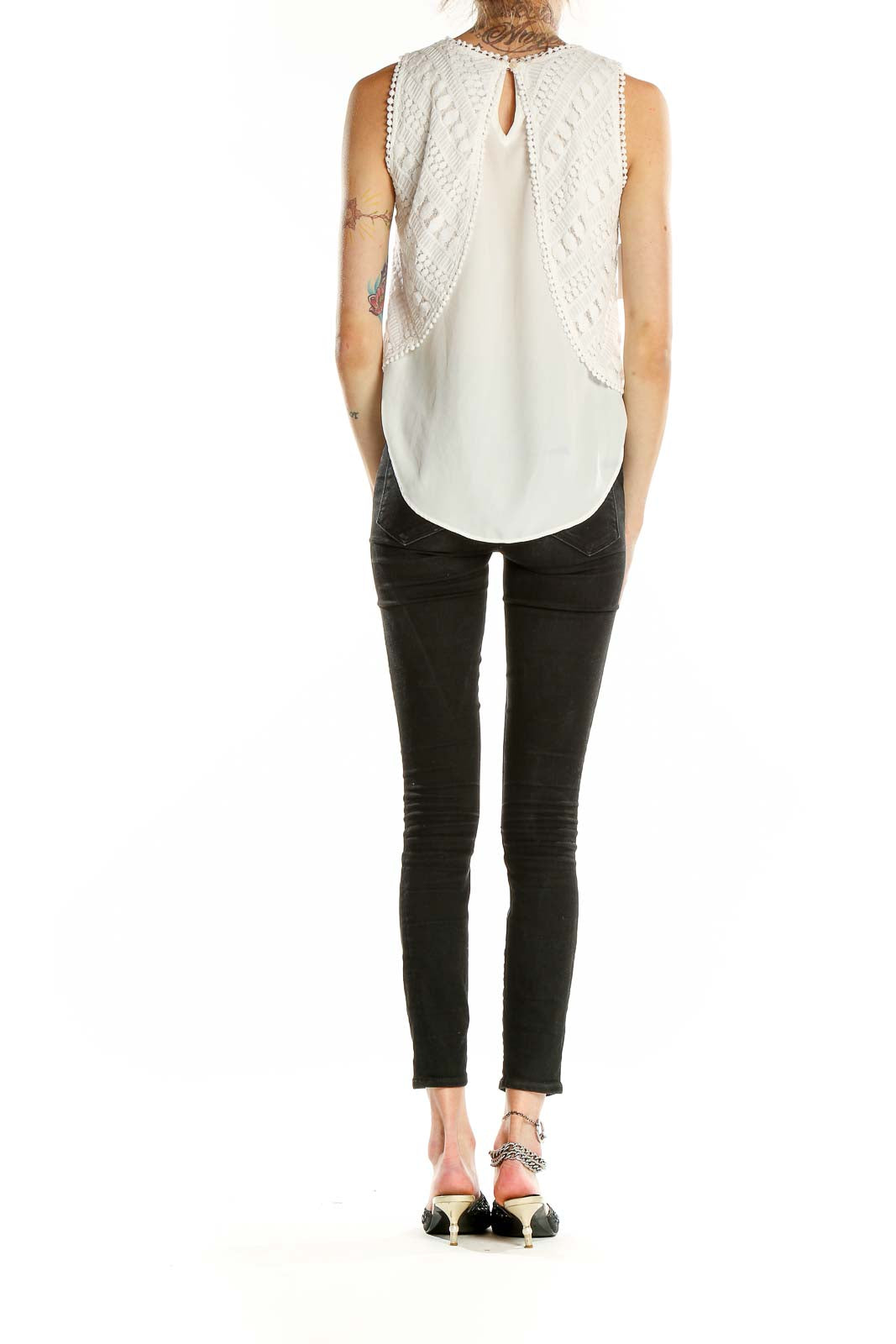 Side view of Greylin white layered crochet sleeveless top with black pants