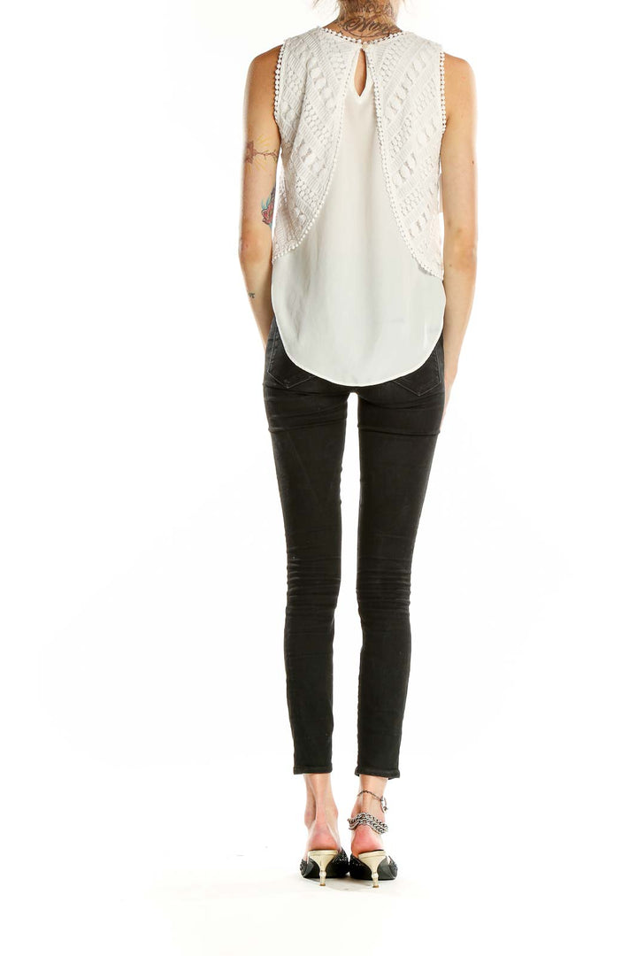 Side view of Greylin white layered crochet sleeveless top with black pants