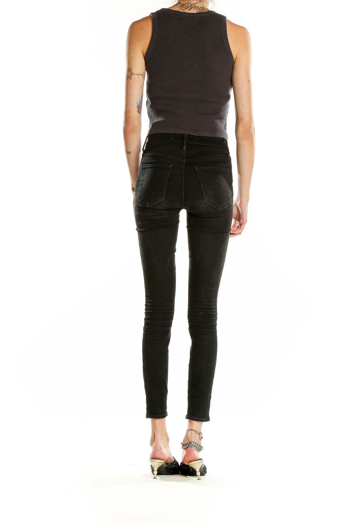 Side view of model wearing Madewell charcoal ribbed cropped tank top with black jeans