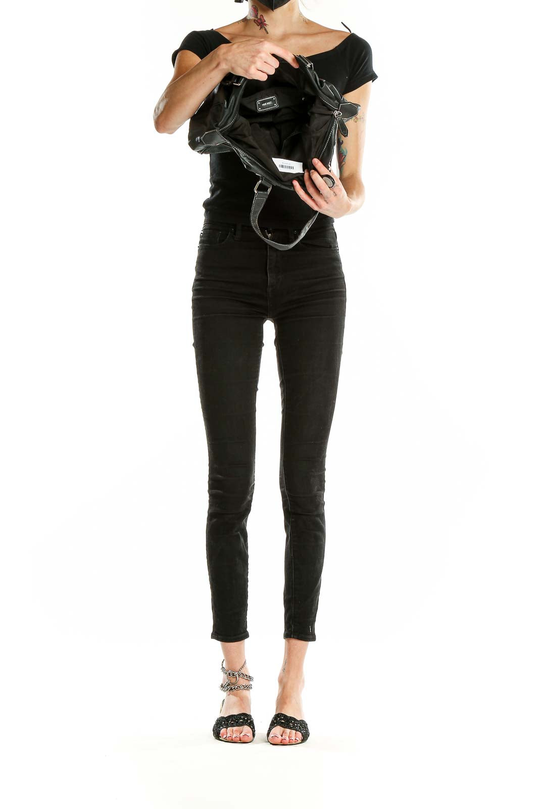 Side view of Nine West black leather shoulder bag worn by model