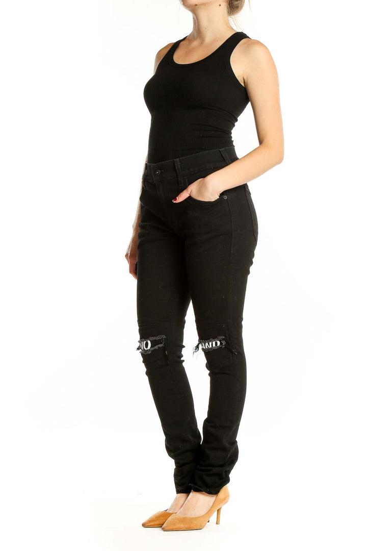 Front view of black distressed skinny jeans with 'NO BRAND' knee cutouts