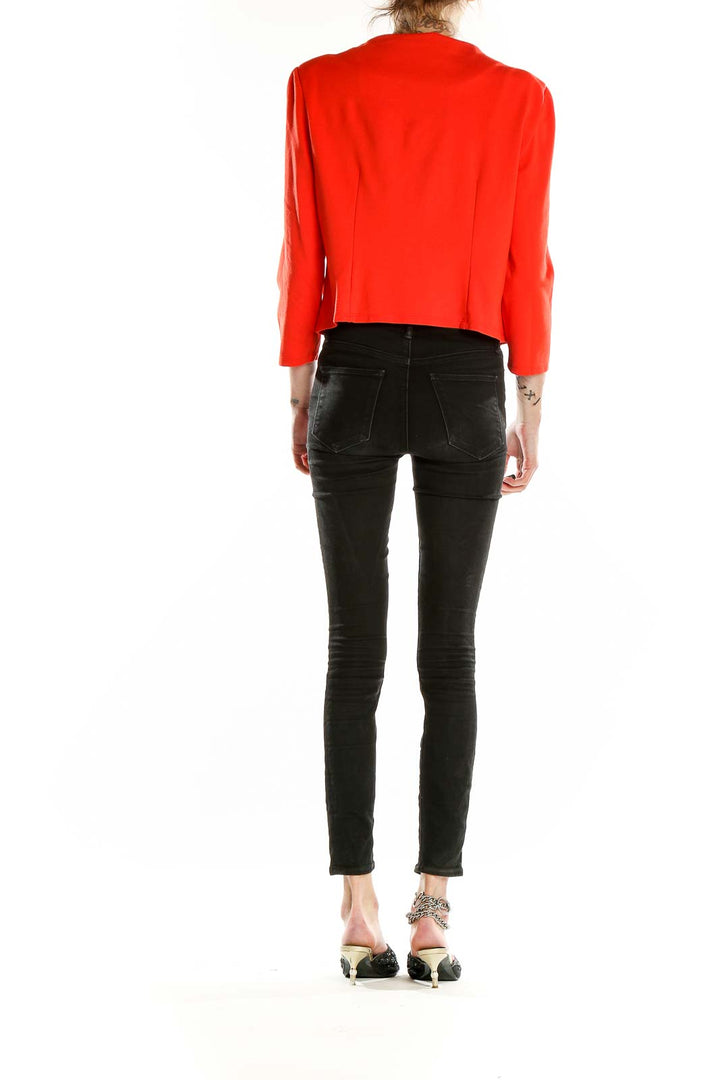 Back view of red Philosophy cropped jacket on model with black pants