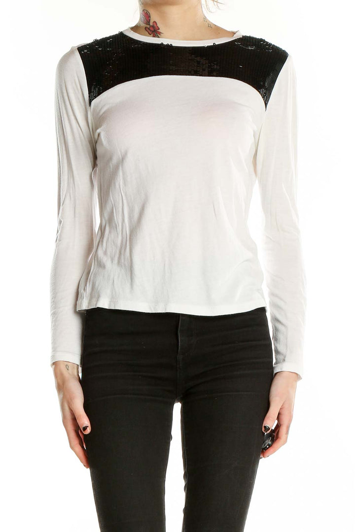 Front view of MICHAEL Michael Kors white long-sleeve top with black sequin shoulder panel