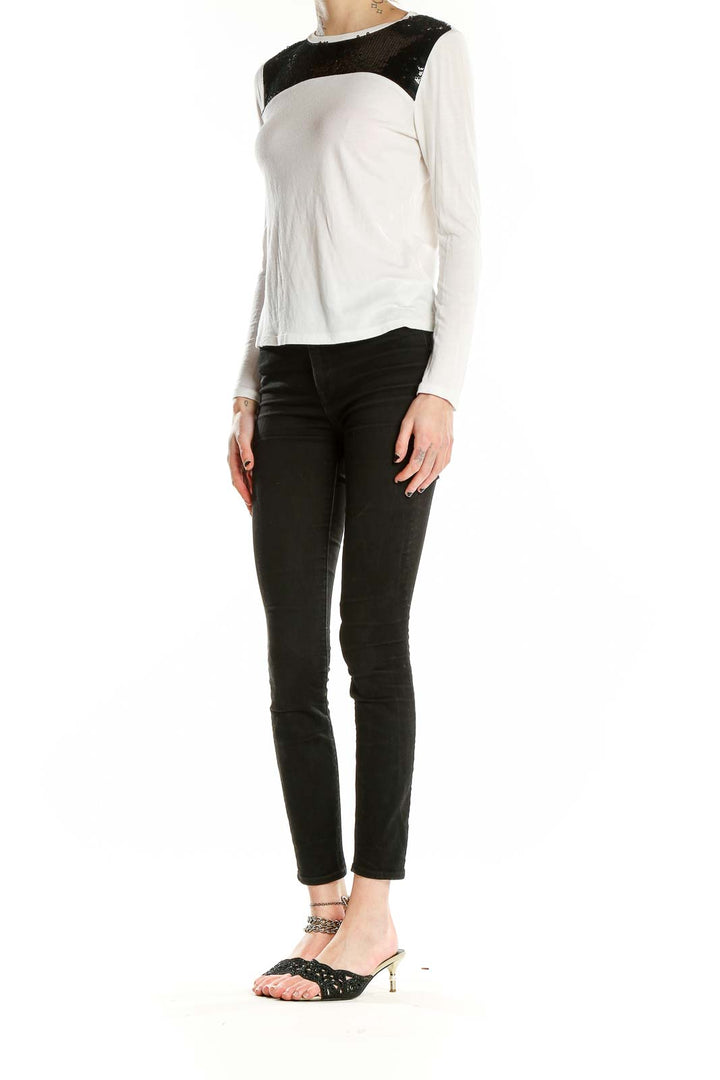 Front view of MICHAEL Michael Kors white long-sleeve top with black sequin shoulder panel