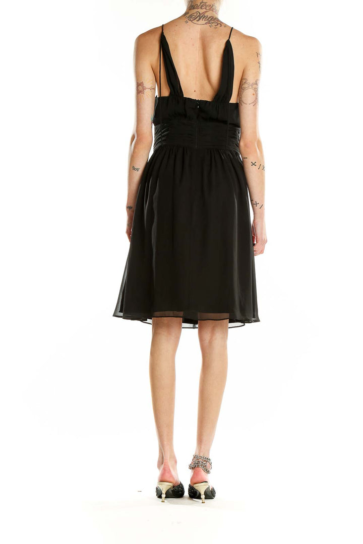 Back view of black halter neck cocktail dress showing low back design
