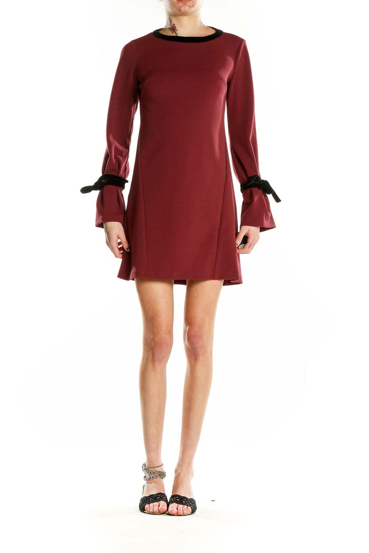 Front view of burgundy Donna Morgan mini dress with bell sleeves and black trim