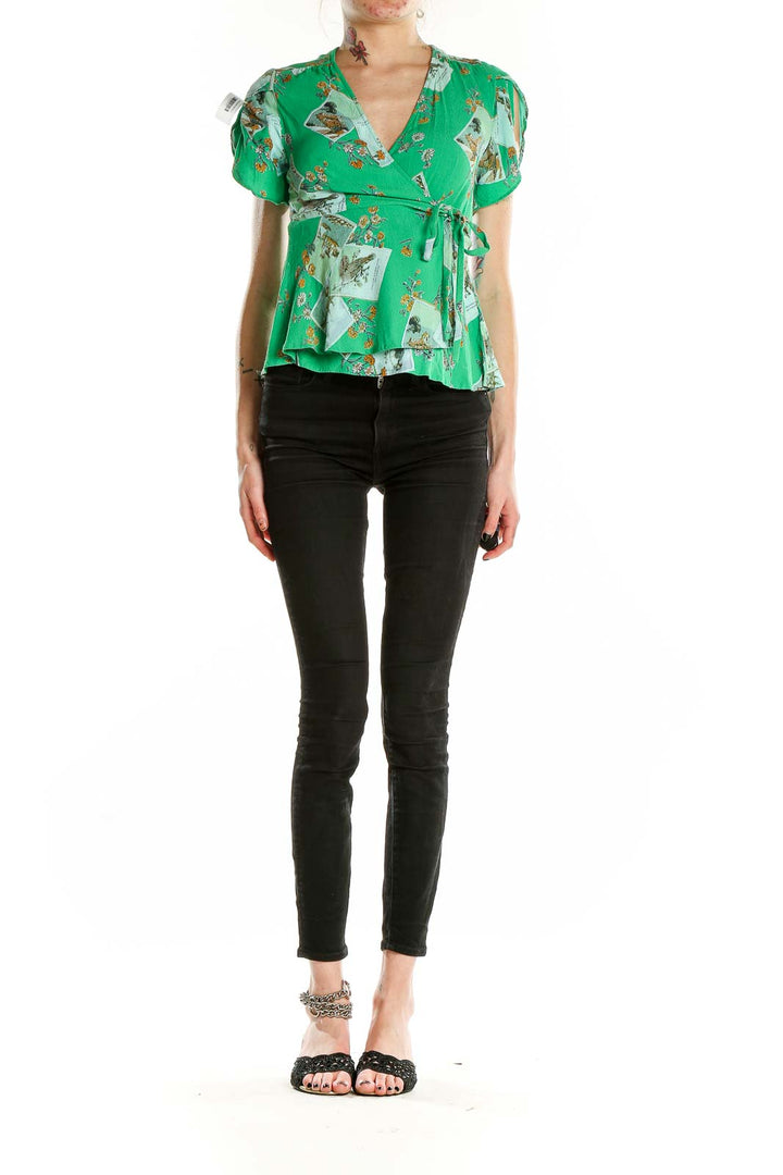 Front view of Meadow Rue green floral wrap blouse with puff sleeves and peplum hem