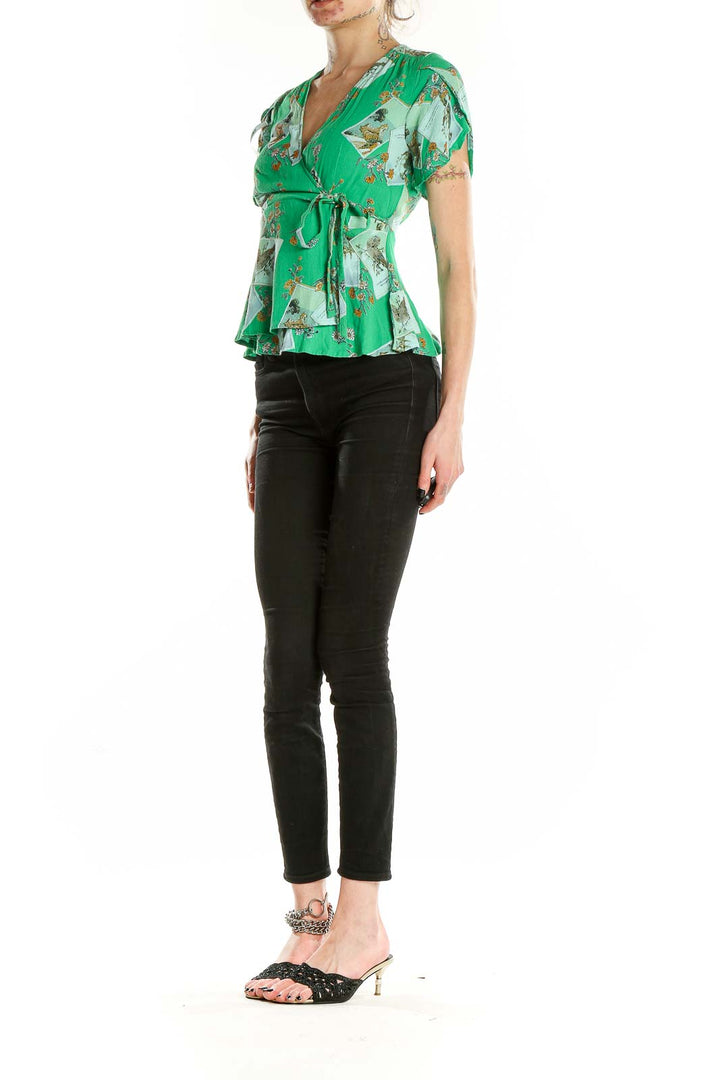 Front view of Meadow Rue green floral wrap blouse with puff sleeves and peplum hem