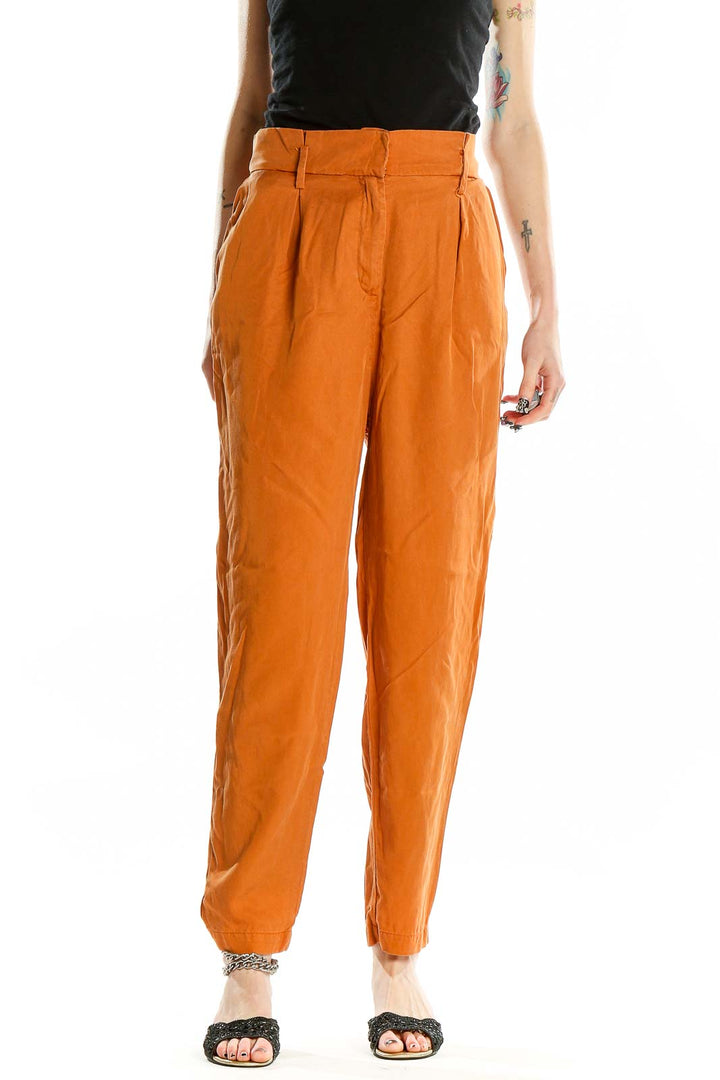 Front view of orange high-waisted pleated trousers by Socialite