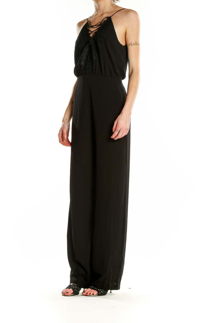 Front view of black Wayf jumpsuit with lace-up neckline and wide-leg pants