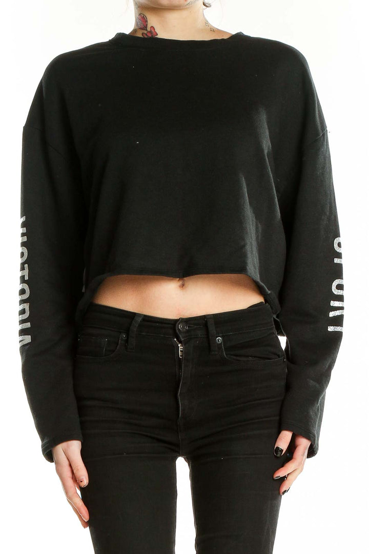 Front view of black Victoria Sport cropped long sleeve top with text on sleeves