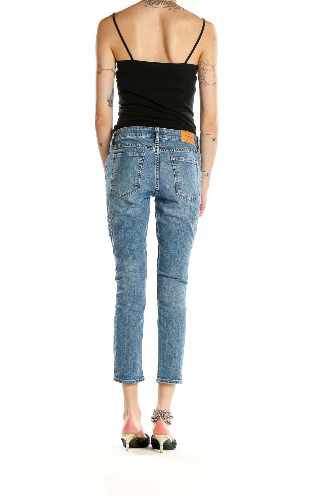 Back view of Lucky Brand blue distressed cropped jeans on model