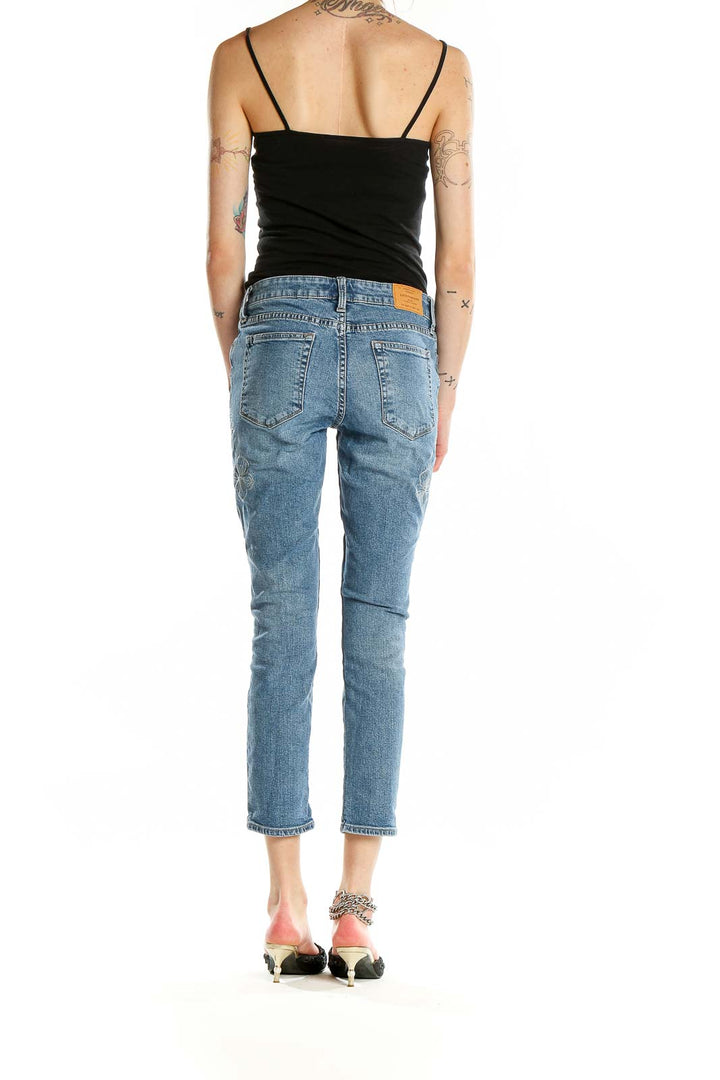 Back view of Lucky Brand blue distressed cropped jeans on model