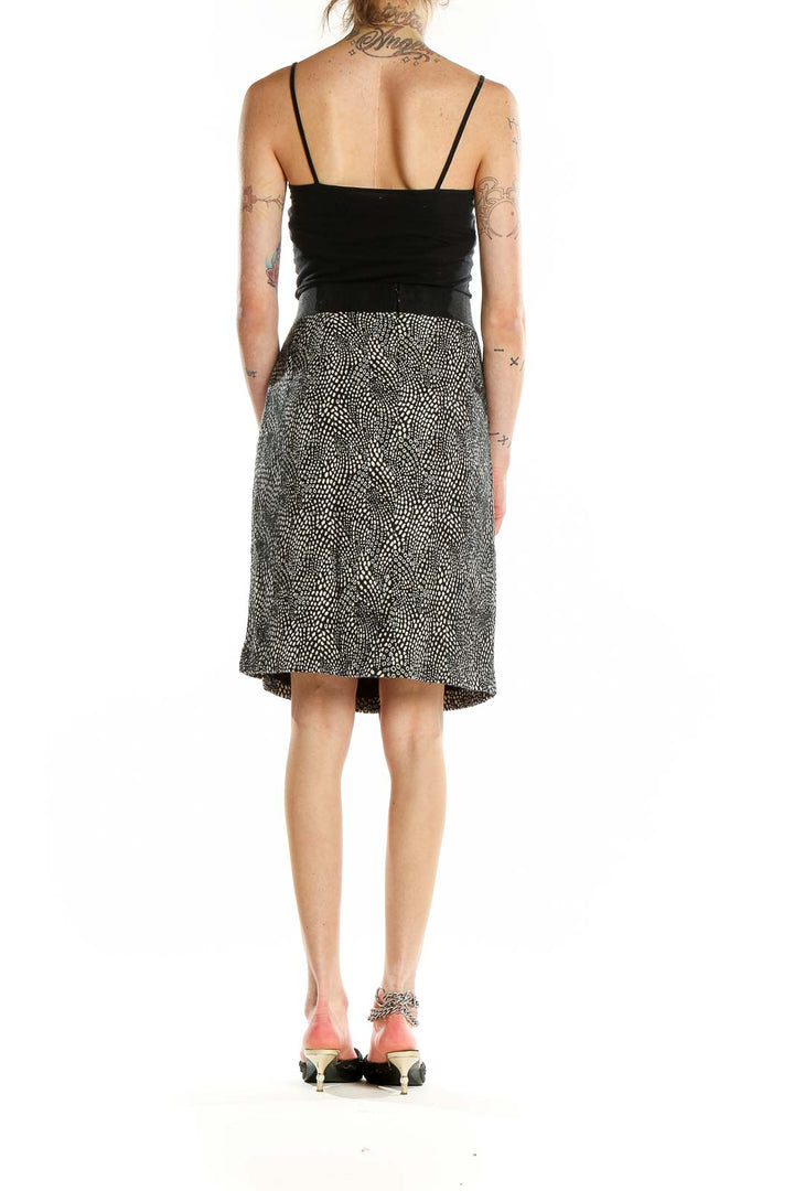 Back view of Ann Taylor black and white dotted A-line skirt on model