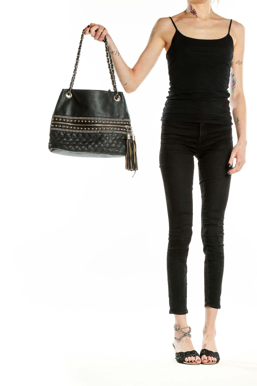 Front view of black quilted shoulder bag with gold studs and chain strap