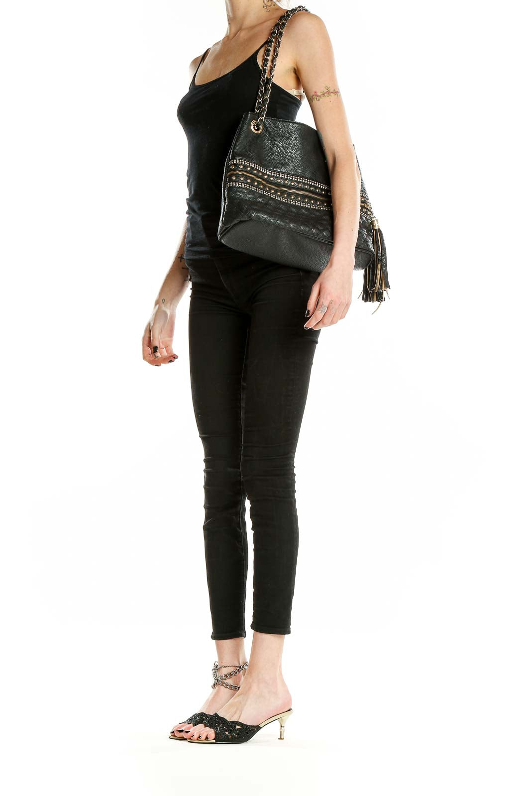 Front view of black quilted shoulder bag with gold studs and chain strap
