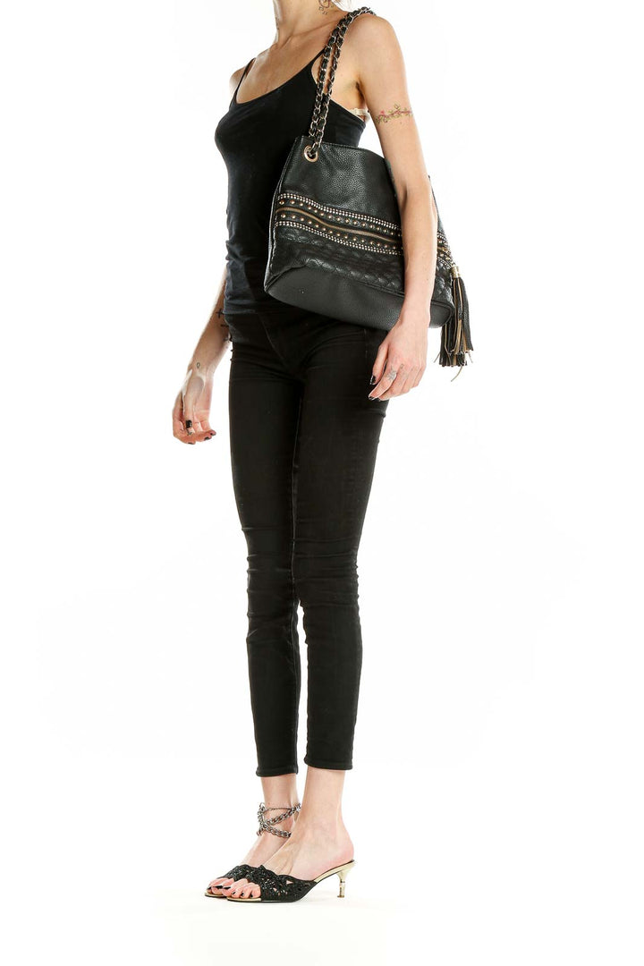 Front view of black quilted shoulder bag with gold studs and chain strap