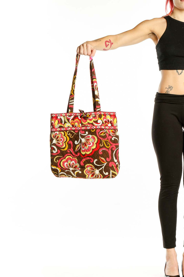 Front view of Vera Bradley brown floral quilted tote bag held by hand