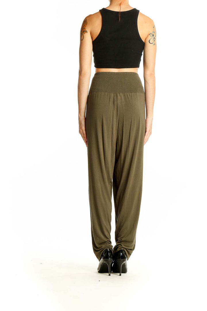 Side view of model wearing Torrid olive high-waisted wide-leg pants with black crop top