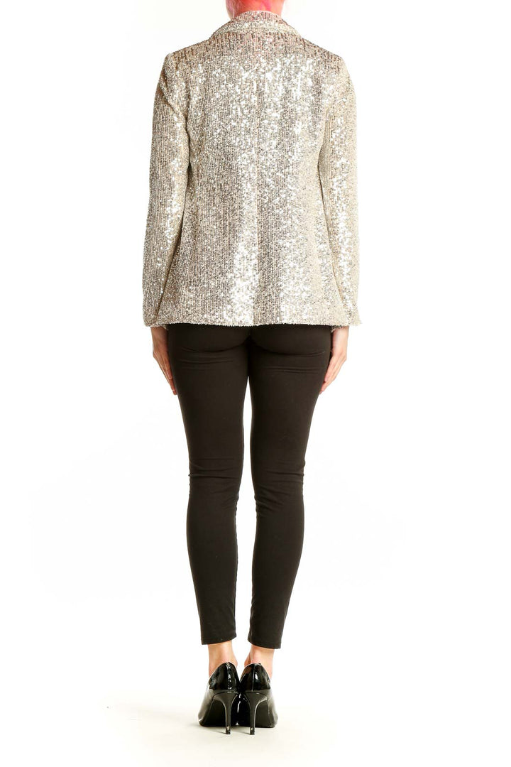 Side view of model wearing Banana Republic silver sequin blazer with black outfit