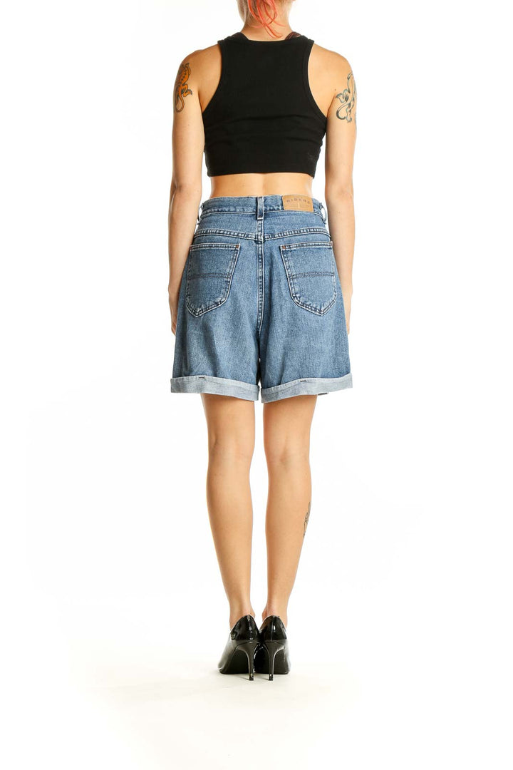 Side view of model wearing Riders by Lee light blue high-waisted denim shorts with black crop top