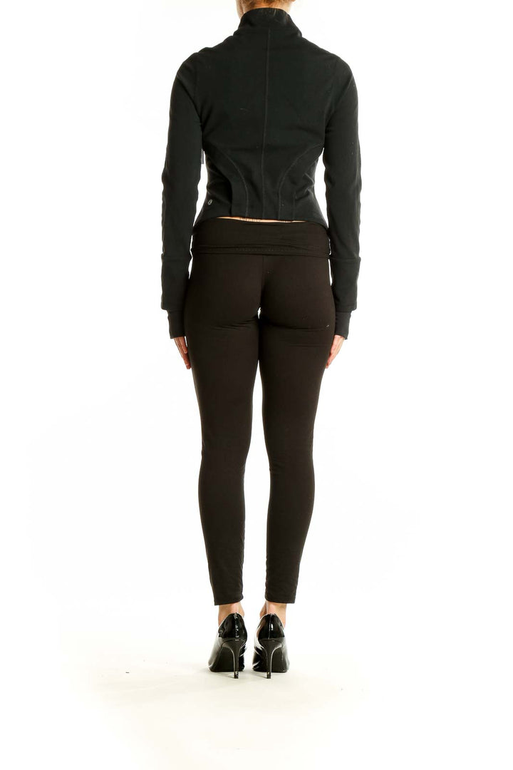 Back view of black Lululemon fitted activewear jacket on model