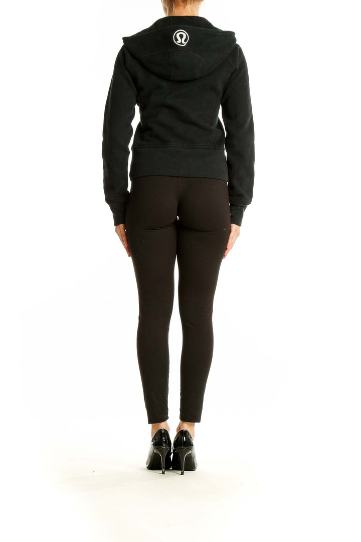 Back view of black Lululemon hooded zip-up athletic jacket on model