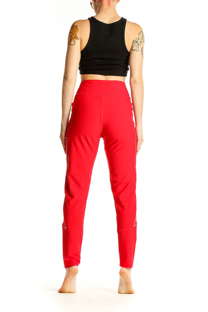 Side view of woman wearing red Victoria Sport high-waisted leggings and black crop top