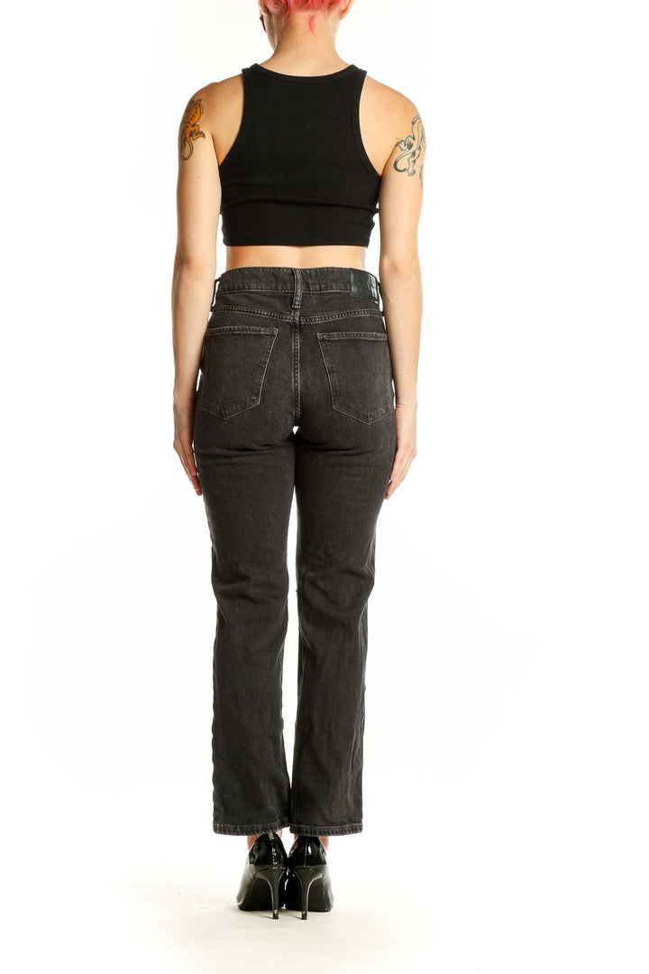 Side view of model wearing Lucky Brand black distressed straight leg jeans with crop top